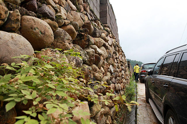 油石鄉(xiāng)梅嶺小學(xué)路口較窄，車隊(duì)只能停在路邊，步行上去